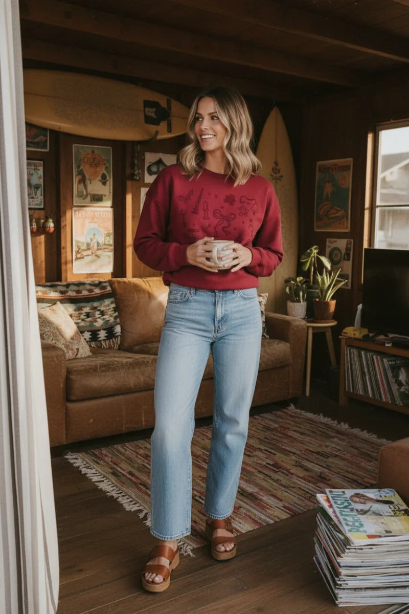 Long sleeve Christmas graphic sweater with embroidered details, blue jeans, brown sandals
