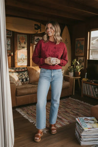Long sleeve Christmas graphic sweater with embroidered details, blue jeans, brown sandals