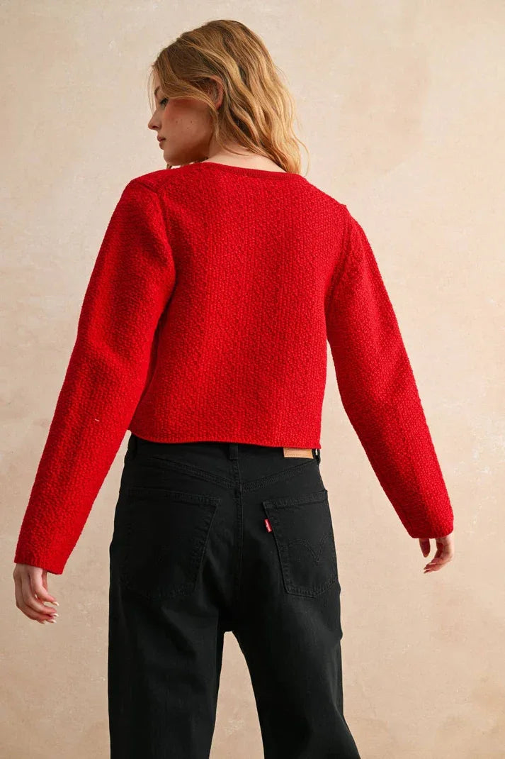 Red textured long sleeve cardigan with black pants and belt