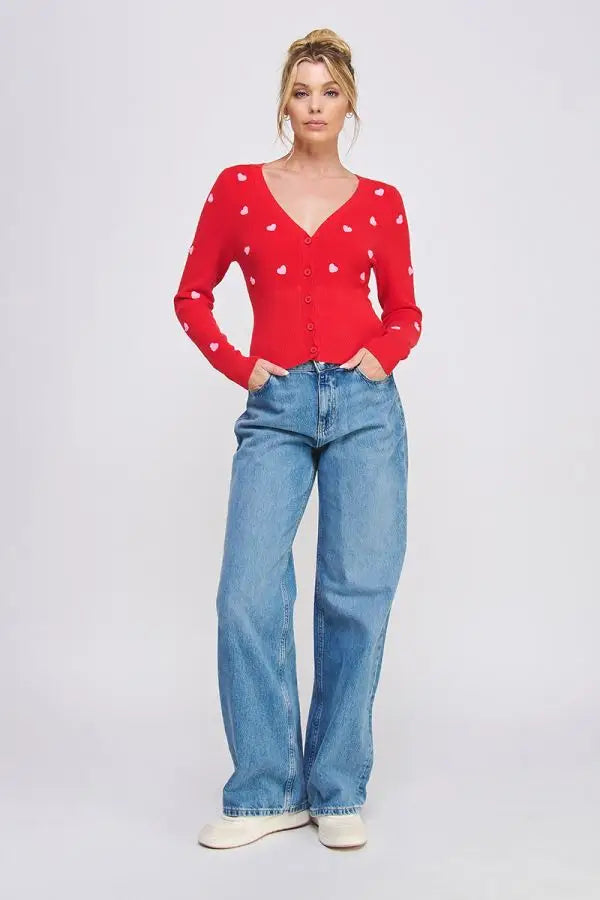 Red v-neck sweater with textured hearts paired with blue jeans, perfect for women’s boho chic clothing