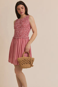 Red and white plaid smocked sleeveless mini dress displayed in PLAID SMOCKED SLEEVELESS MINI DRESS