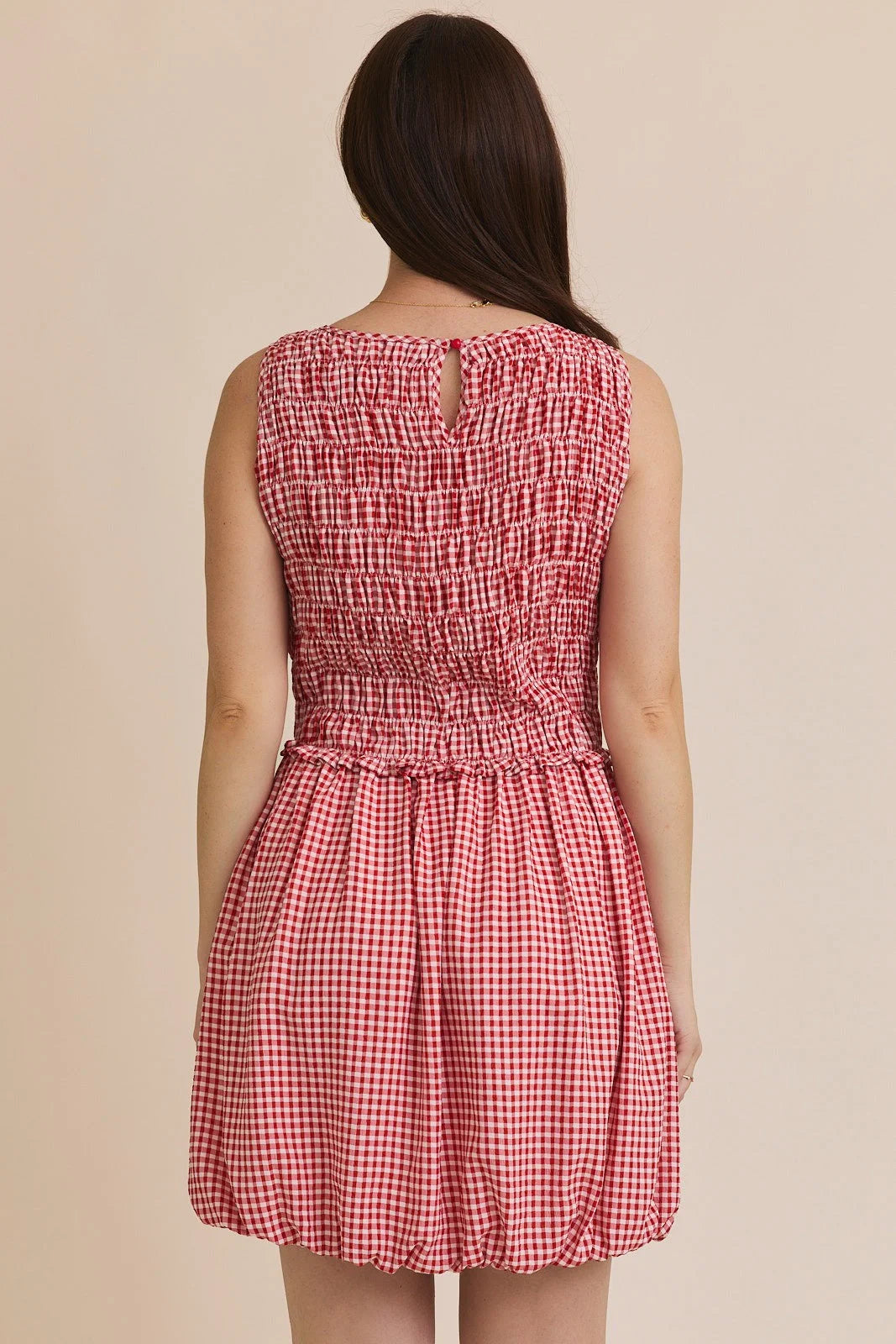 Red and white plaid smocked sleeveless mini dress displayed in PLAID SMOCKED SLEEVELESS MINI DRESS