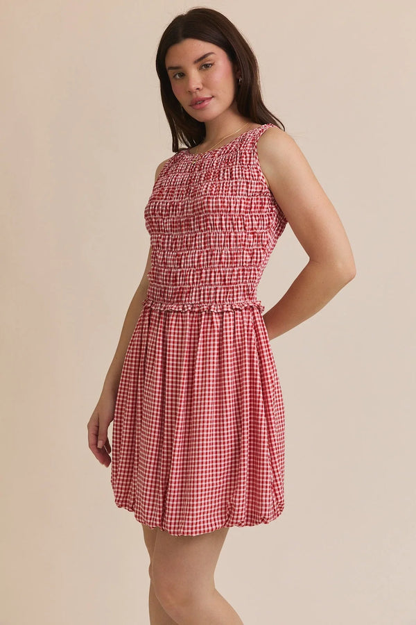 Red and white gingham plaid smocked sleeveless mini dress displayed in PLAID SMOCKED SLEEVELESS MINI DRESS