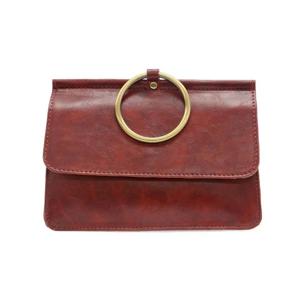 Reddish-brown leather clutch with brass ring handle showcasing widest point and interior zip in ARIA RING BAG