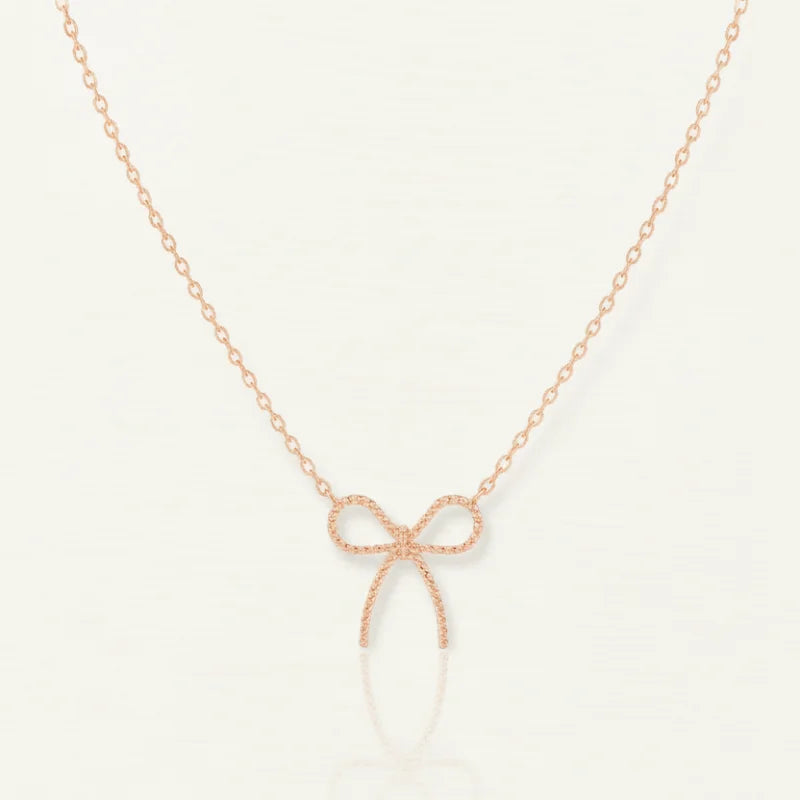 Dainty rose gold bow necklace with textured bow pendant and diamond accents