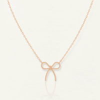 Dainty rose gold bow necklace with textured bow pendant and diamond accents