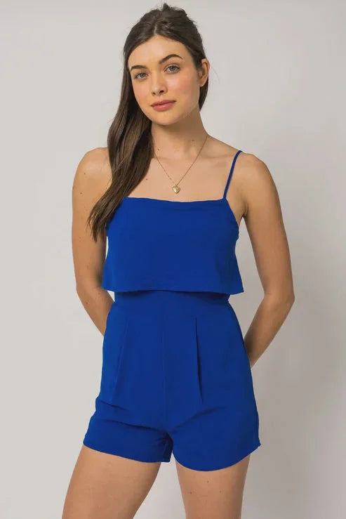 Royal blue sleeveless pocket layered romper with ruffled overlay, perfect for women’s boho chic clothing from Shop Daisy
