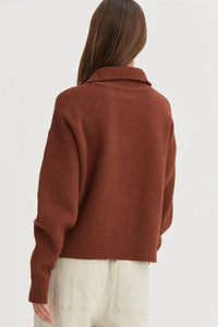 Rust-colored drop shoulder half zip sweater with collared neckline worn from behind