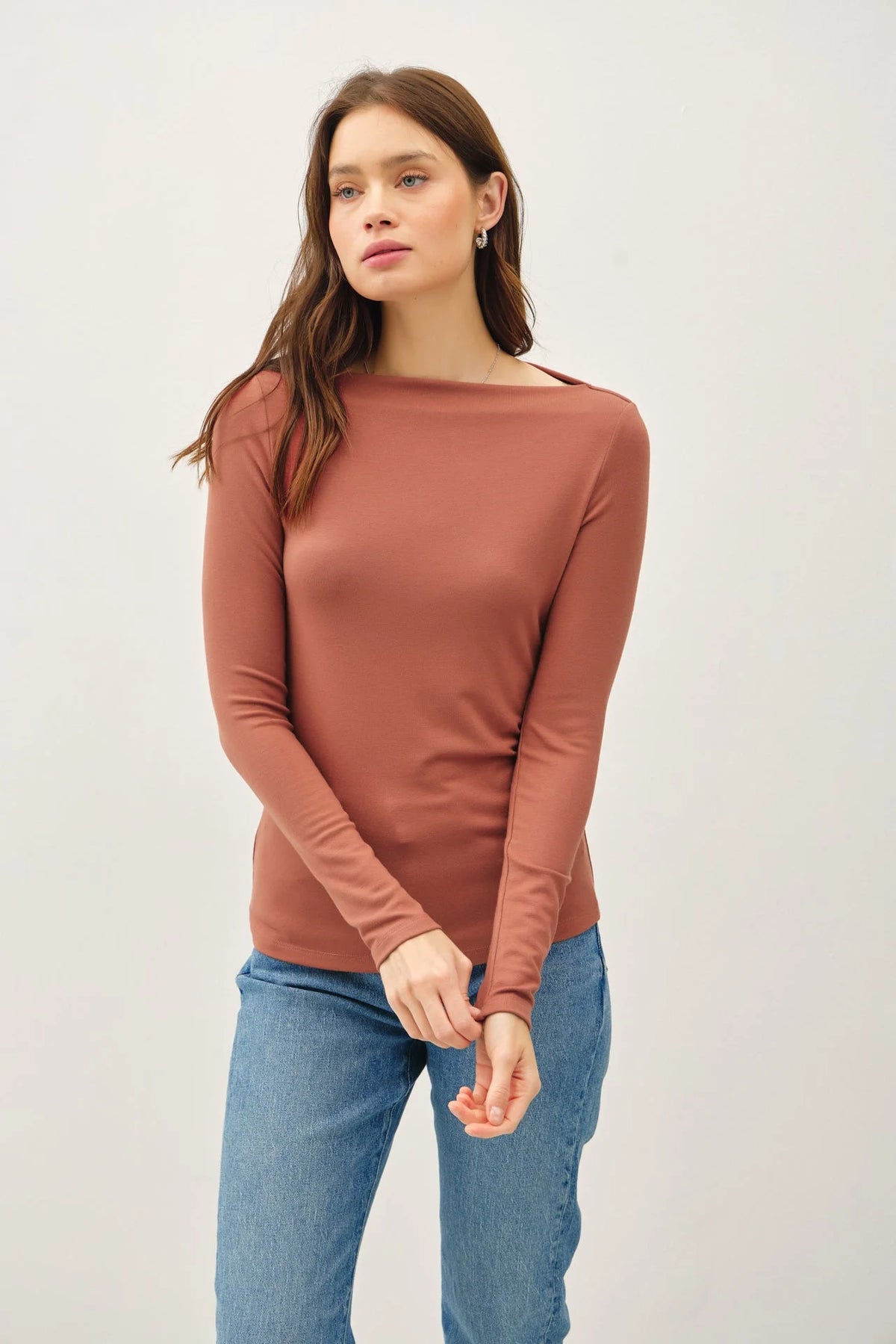 Rust-colored long sleeve fitted knit top featuring a classic boat neck design