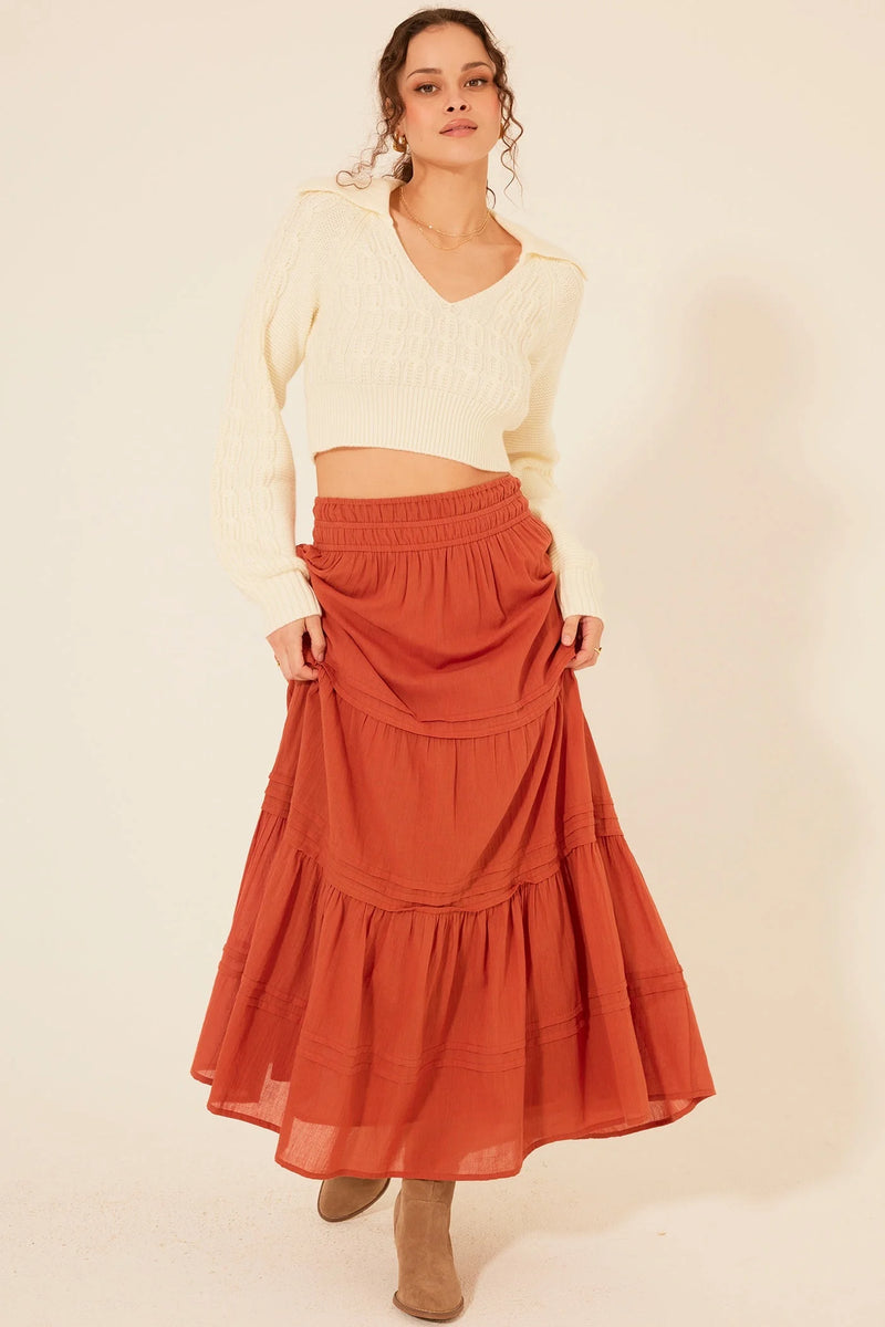 Flowing rust-colored Zella Maxi Skirt featuring elegant tiered ruffles