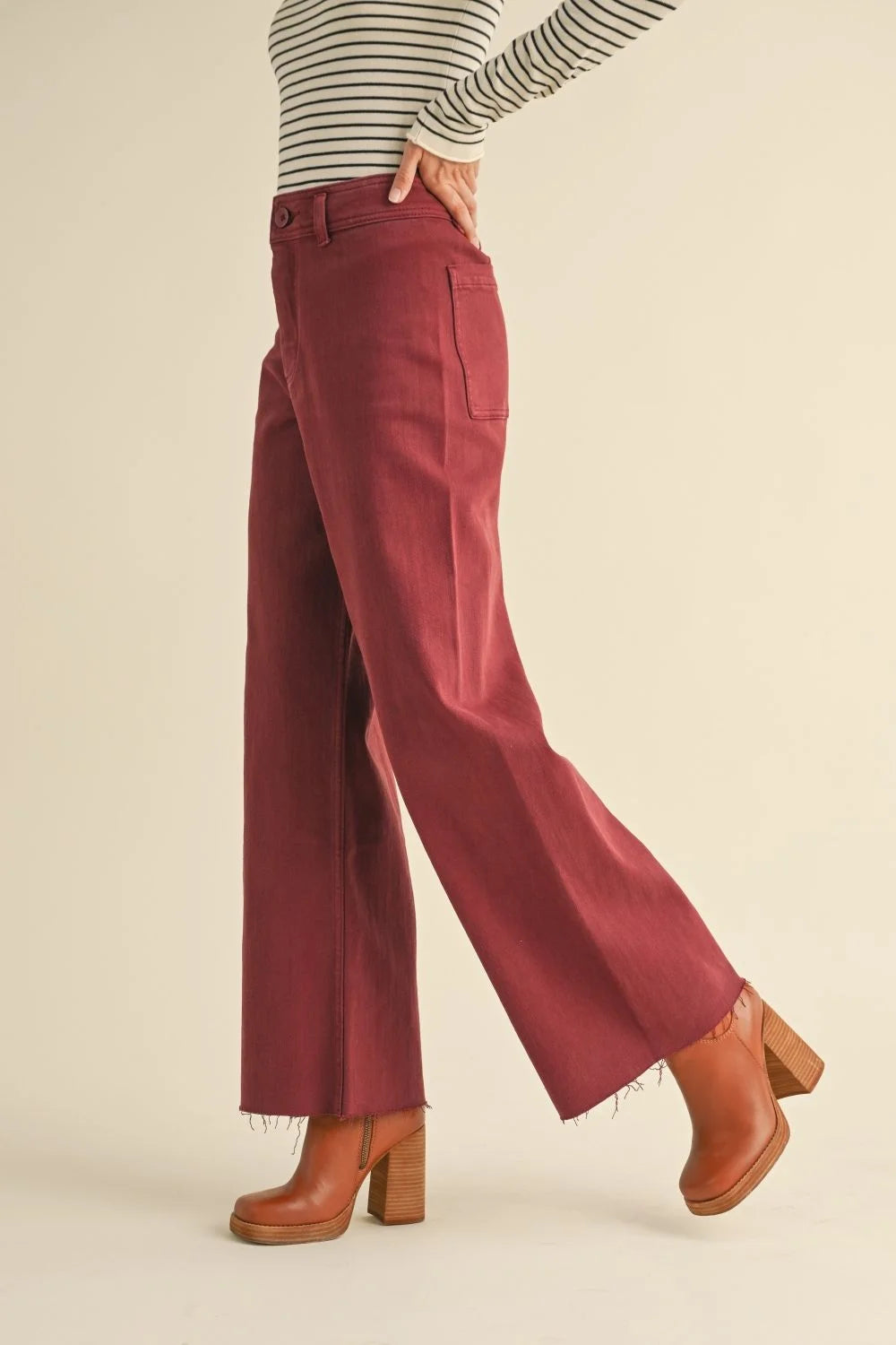 Rust-colored straight wide leg denim pants with frayed hems for a stylish look