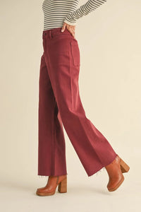 Rust-colored straight wide leg denim pants with frayed hems for a stylish look