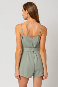 Sage green flowy romper with tie waist and thin shoulder straps for a boho vibe