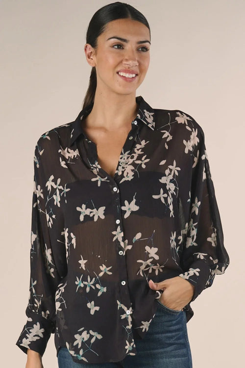 Sheer long sleeve button-down floral top with black fabric and white floral print