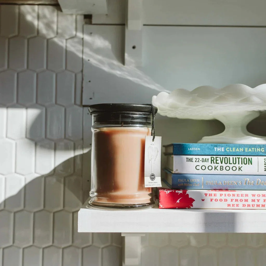 Shelf featuring the Sweet Grace Candle, best seller soy wax blend jar with books