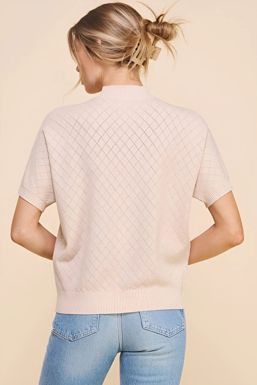 Soft short sleeve crosshatch mock neck top paired with blue jeans, cream-colored sweater