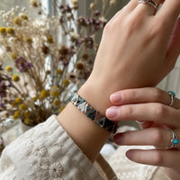 Silver and black beaded Bohemian Live Love Laugh bracelet with geometric pattern