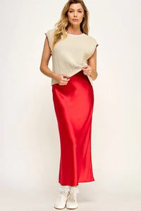 Sleek red satin midi skirt with cream sleeveless vest sweater and white sneakers