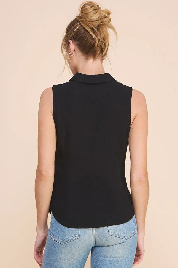 Blonde person in bun wearing a sleeveless collared shirt in black linen