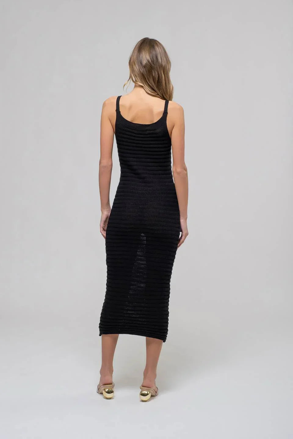 Sleeveless black ribbed cami midi dress paired with elegant gold heels