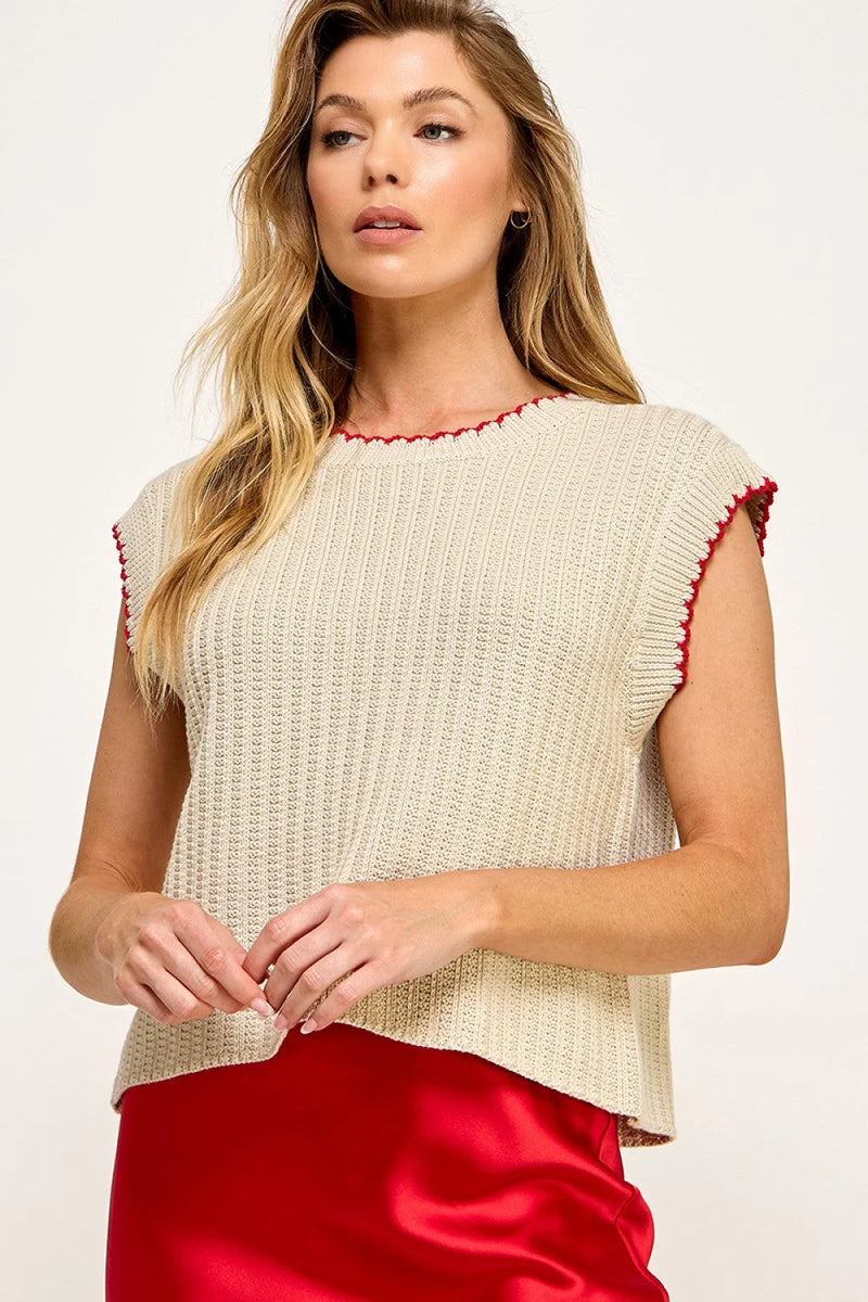 Sleeveless vest sweater featuring a cream color and red trim detailing