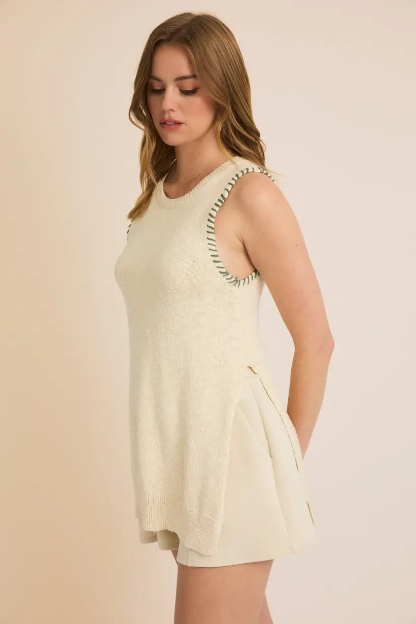 Sleeveless cream-colored romper featuring round neck and side open stitch detail