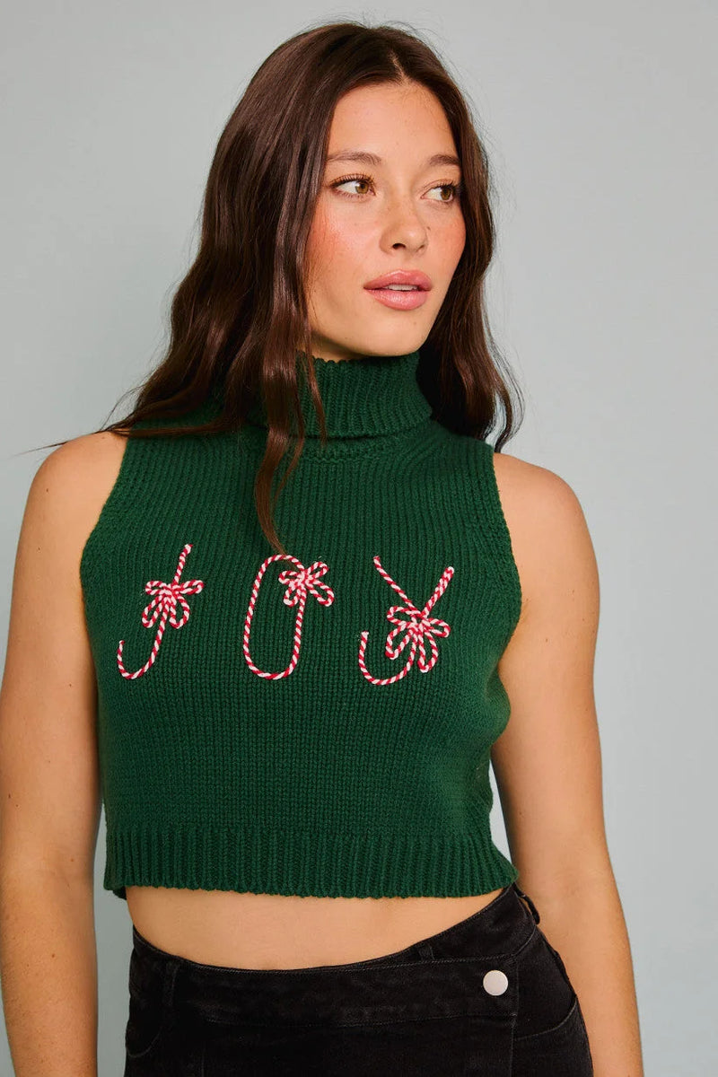 Sleeveless green turtleneck crop top featuring JOY in candy cane-style lettering