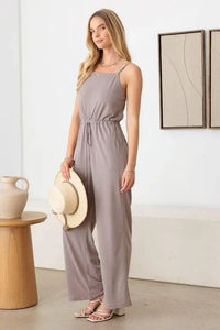 Sleeveless taupe jumpsuit with drawstring waist and wide-leg pants for a boho look