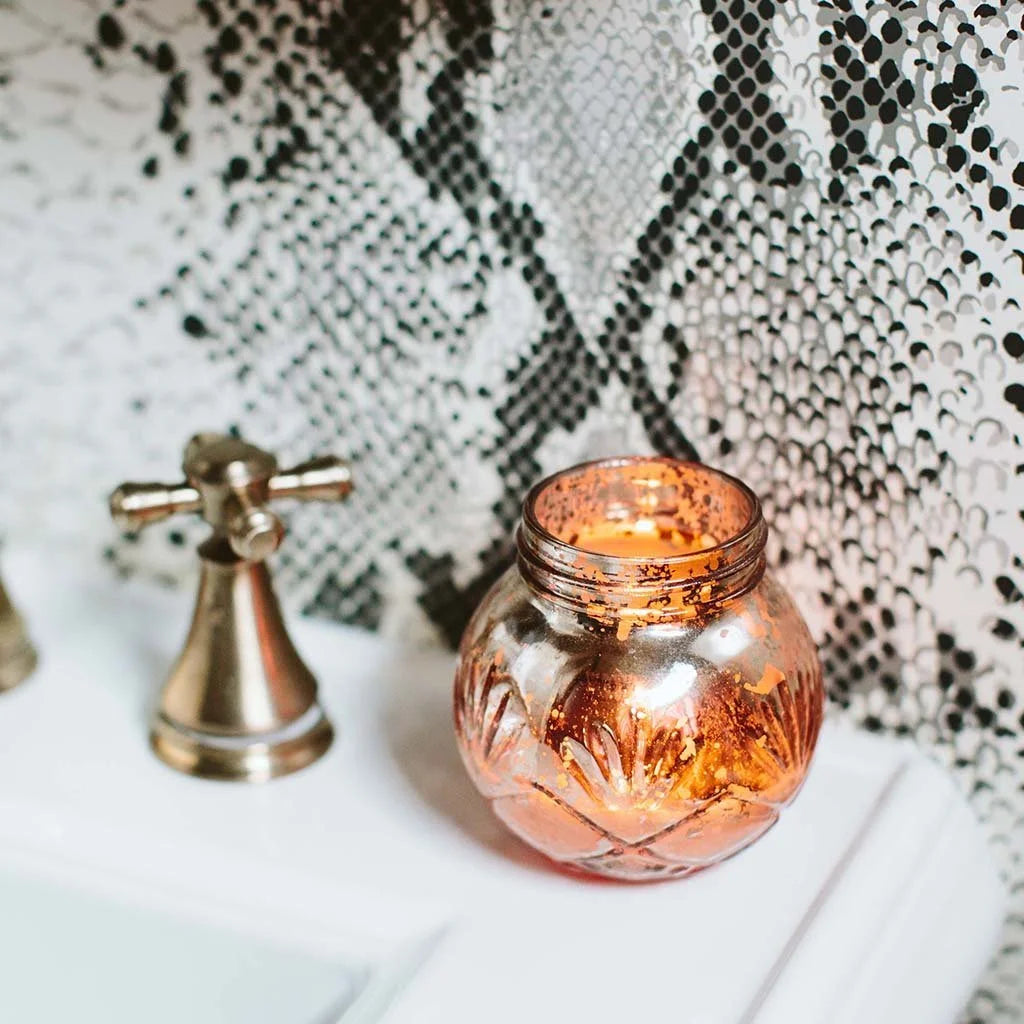 Small jar with water and a candle showcasing the Sweet Grace soy-blend wax candle