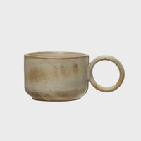 Small stoneware mug with a handle featuring a unique reactive glaze finish