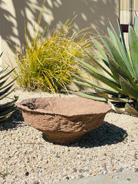 Small planter on gravel beside a decorative handmade paper mache bowl