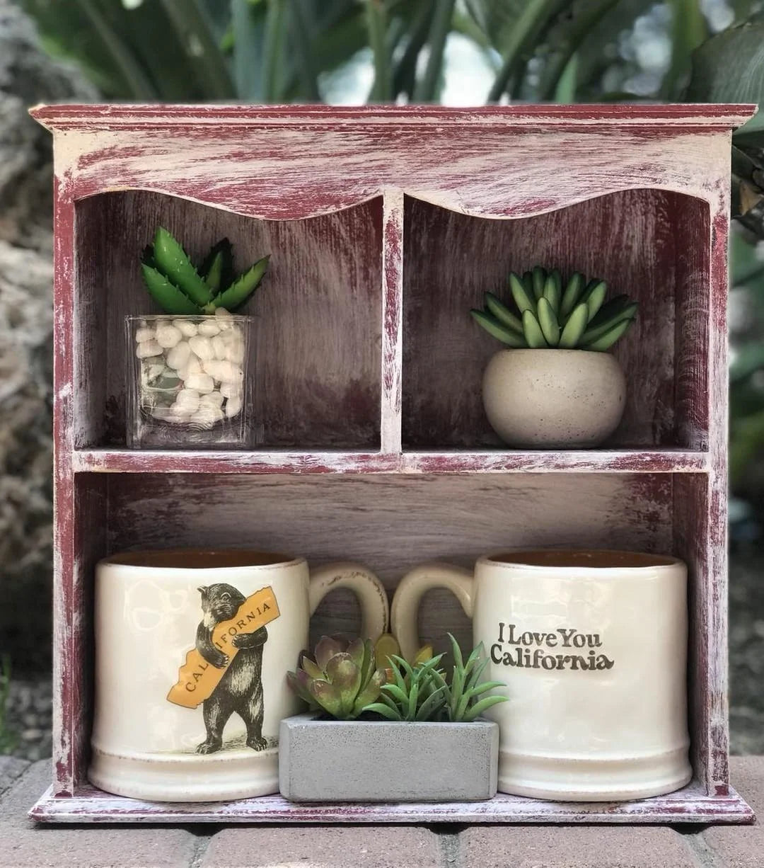 Small shelf showcasing I LOVE YOU CALIFORNIA Bear Hug Mug with plants and mugs