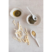 Spoons and bowls of food on a table featuring a Stoneware Strainer Spoon