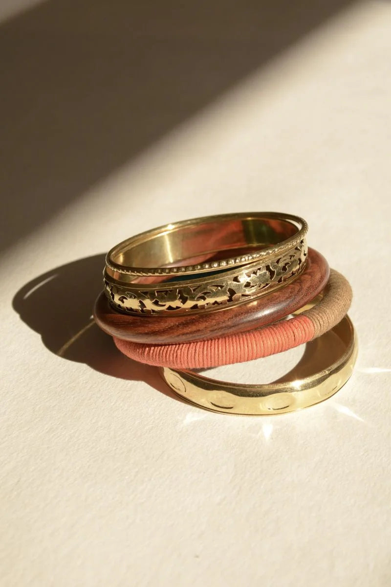 Bohemia Stacked Wood & Brass Bangle with pink ribbon elegantly displayed in a stack of rings