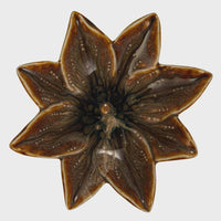 Brown glossy stoneware flower shaped dish with eight-pointed star design for decorative use