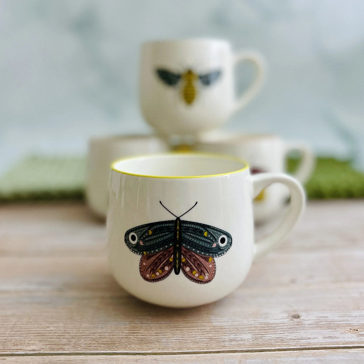White stoneware mug with vibrant colored rim and butterfly design for tea or coffee