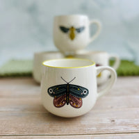 White stoneware mug with vibrant colored rim and butterfly design for tea or coffee