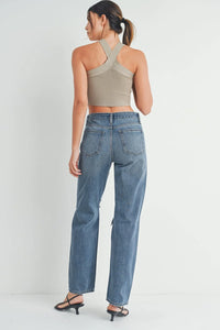 Straight-leg baggy skater jeans with ripped knees paired with a beige crop top