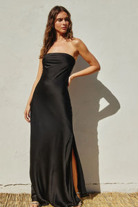 Strapless black maxi dress with side slit, worn by a woman with long brown hair