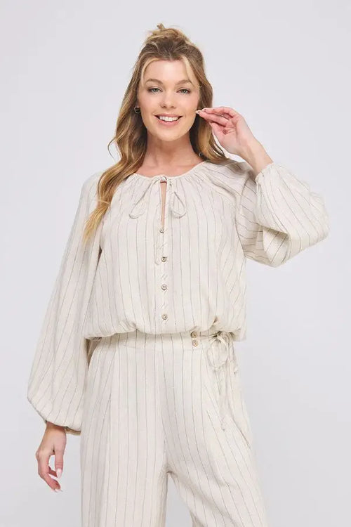 Linen pinstripe relaxed long sleeve blouse displayed as striped beige jumpsuit