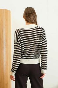 Back view of a striped black and white long sleeve crochet knit sweater