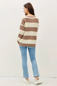 Striped brown and cream cable knit crew neck sweater styled with jeans and sneakers