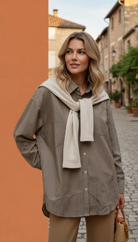 Striped button-down shirt with layered knit sleeves, beige scarf, and brown pants