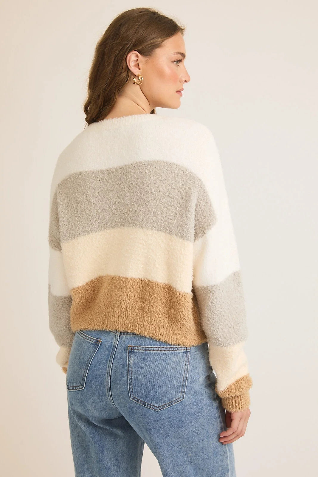 Striped fuzzy round neck color block sweater top in cream, grey, and tan with blue jeans