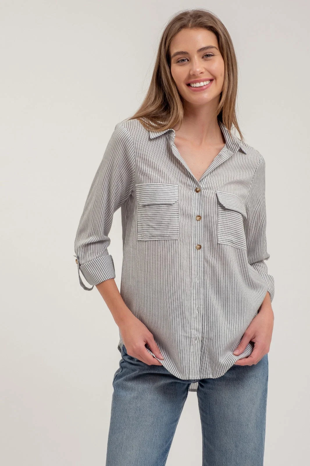 Striped collared button down shirt in gray and white with chest pockets and blue jeans