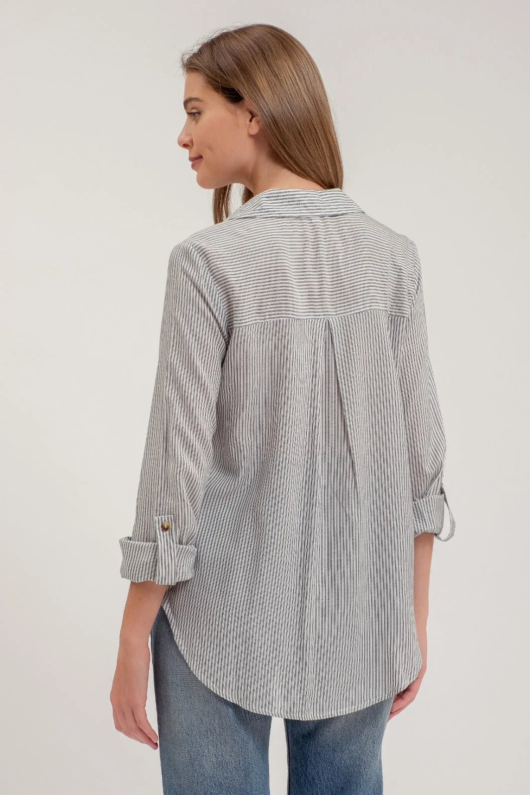 Striped gray and white collared button-down shirt with rolled sleeves and pockets