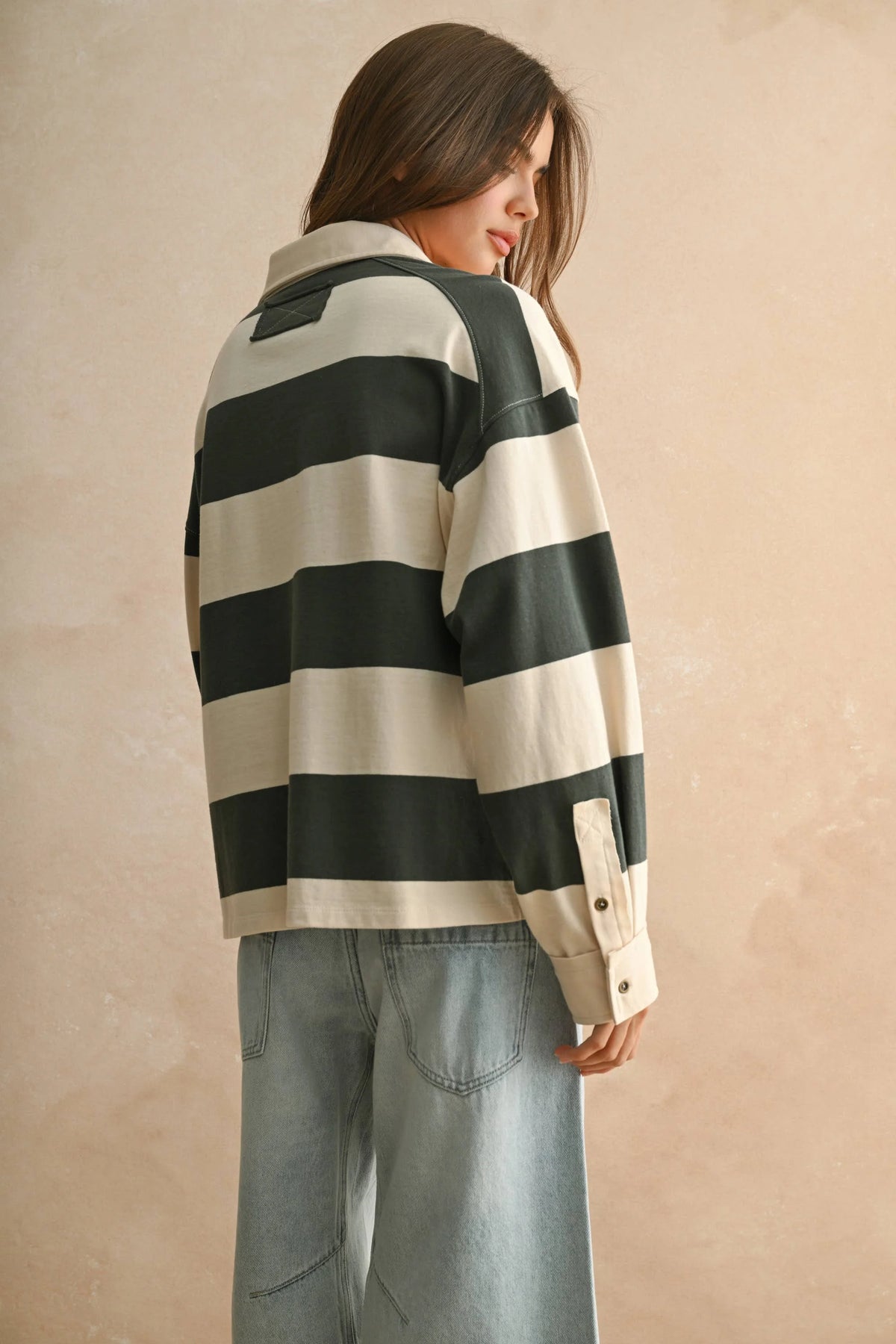 Striped long sleeve wide panel knitted shirt with green and white stripes, button-down collar, and light blue jeans