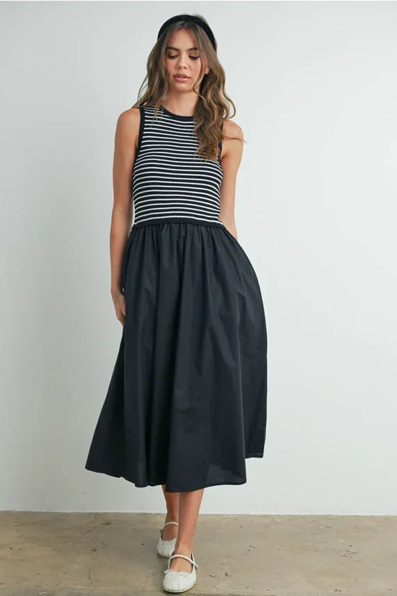 Striped sleeveless maxi dress with black skirt and white shoes