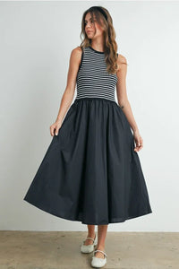 Striped sleeveless maxi dress with black skirt and white shoes