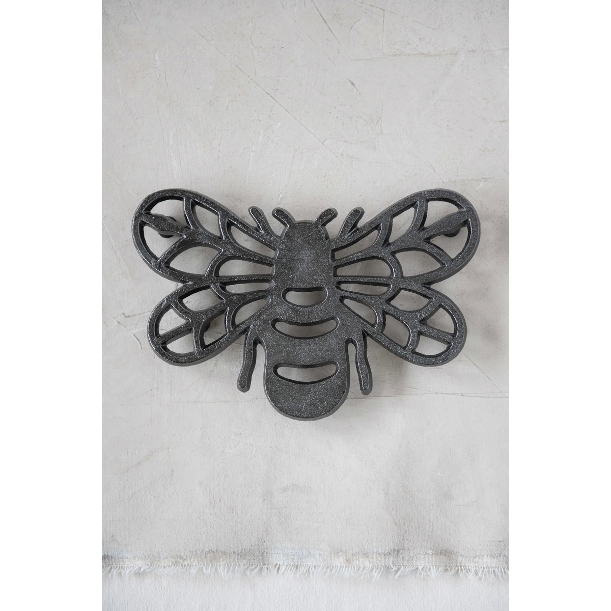 Stylized cast aluminum bee trivet with intricate wing patterns for home decor